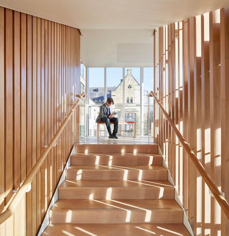 Tonbridge School Smythe Library - pupil on stairs reading